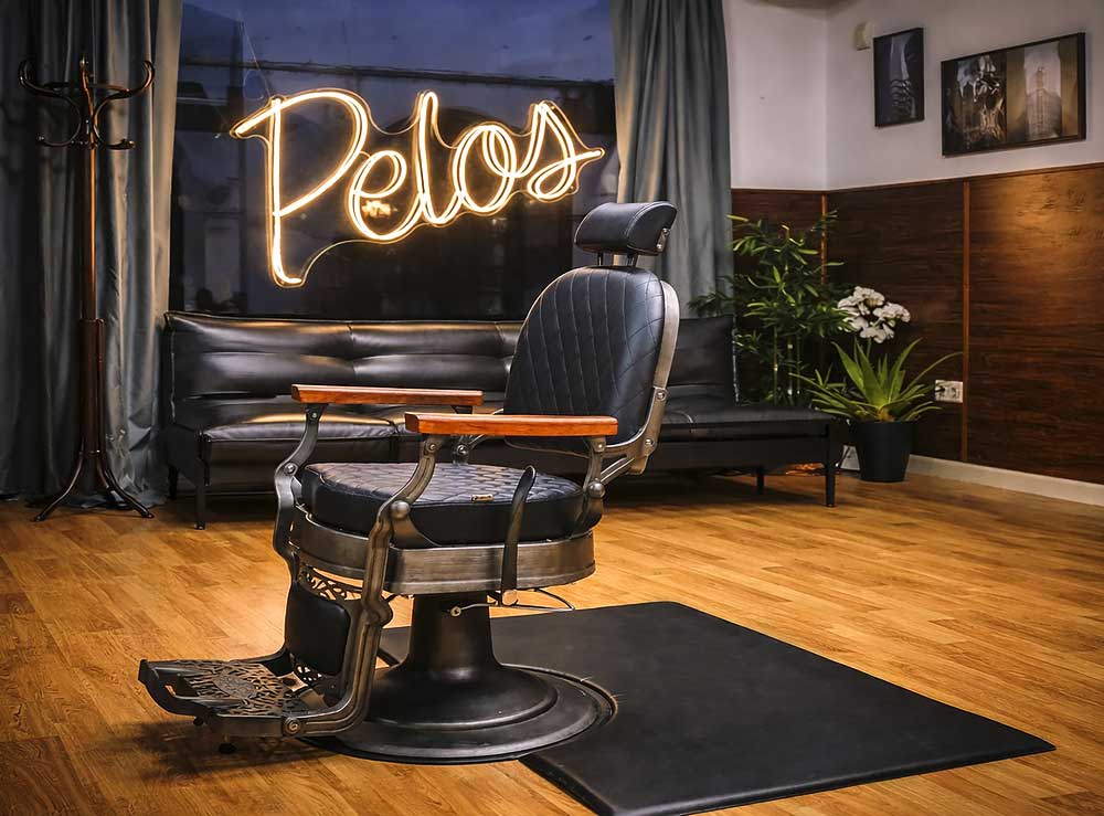 Sillón de barbero vintage y cartel de neón de Peluquería Pelos.